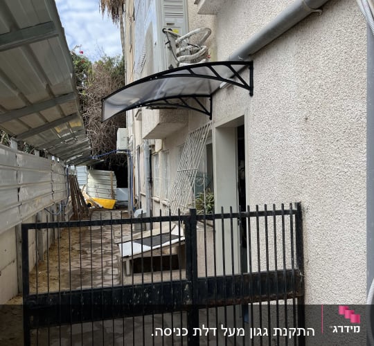 סוכך שחור מותקן מעל דלת כניסה לבניין.